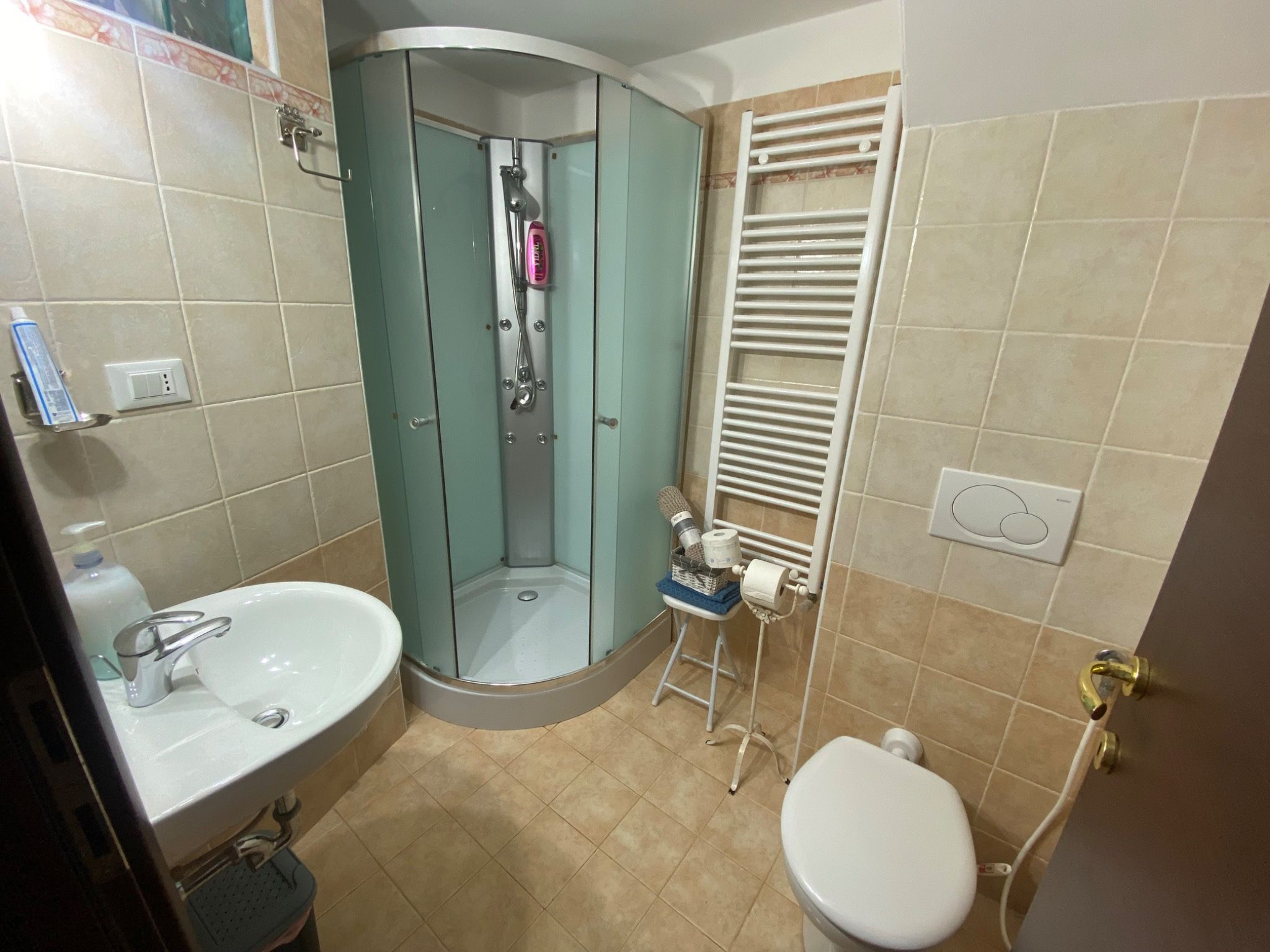 Tiled bathroom with shower and heated towel rail