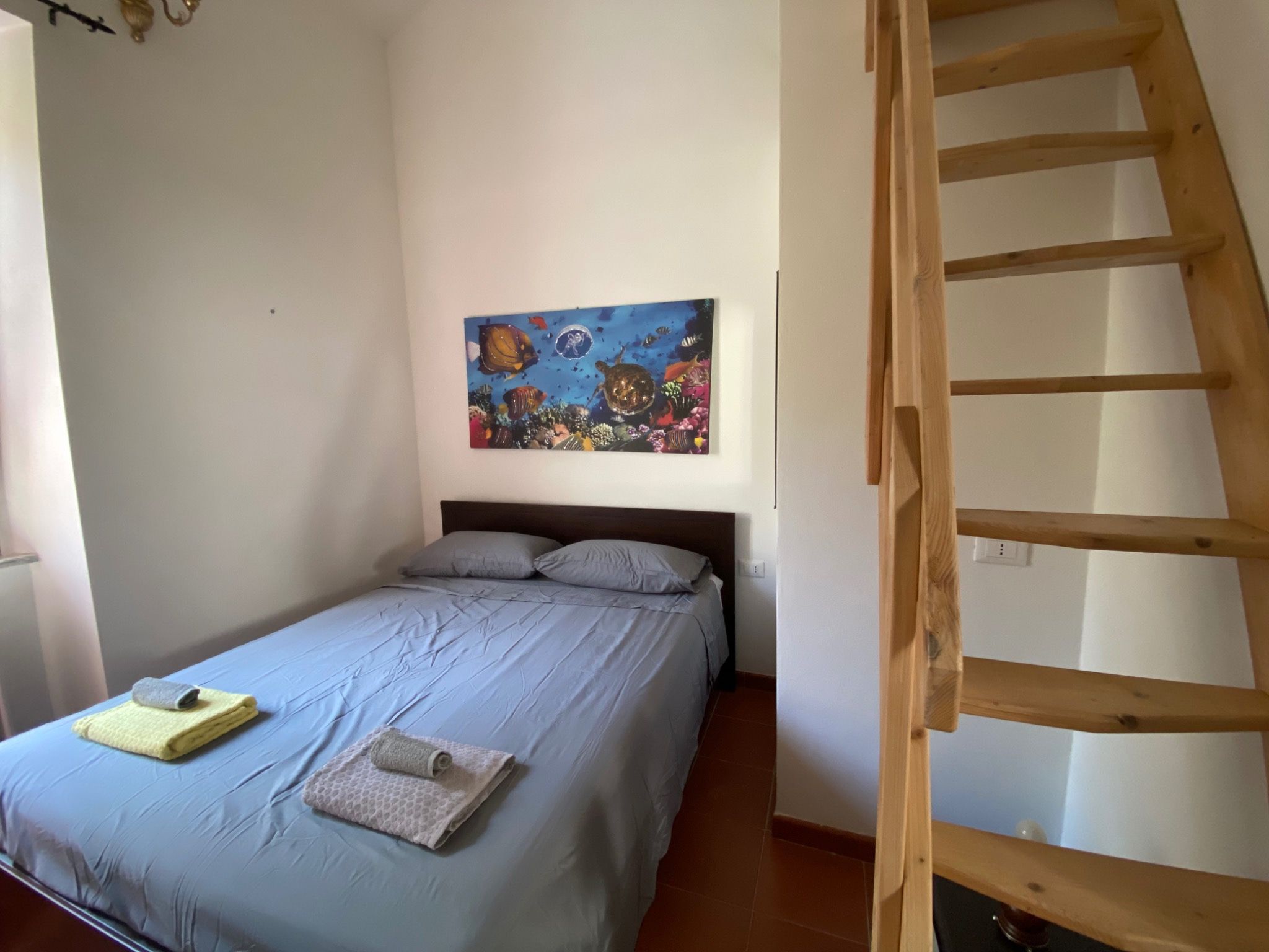 Furnished bedroom with a wooden ladder to the mezzanine