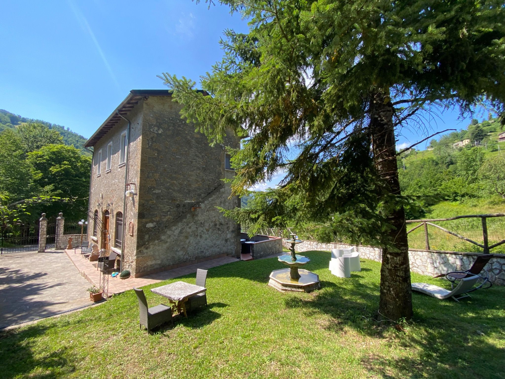 Side of the stone villa and its shaded garden