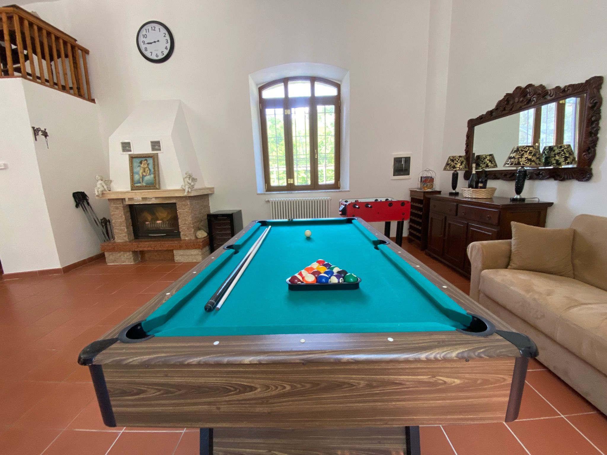 Bright games room with billiards, table football and fireplace
