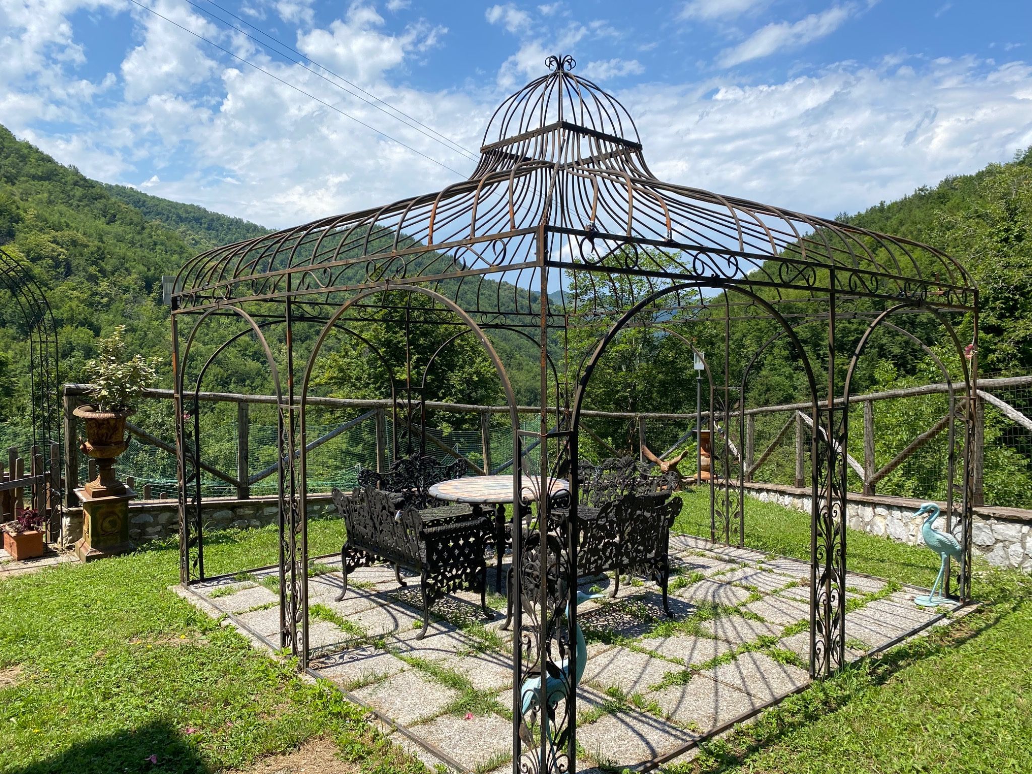 Iron gazebo in the private garden with a green valley view