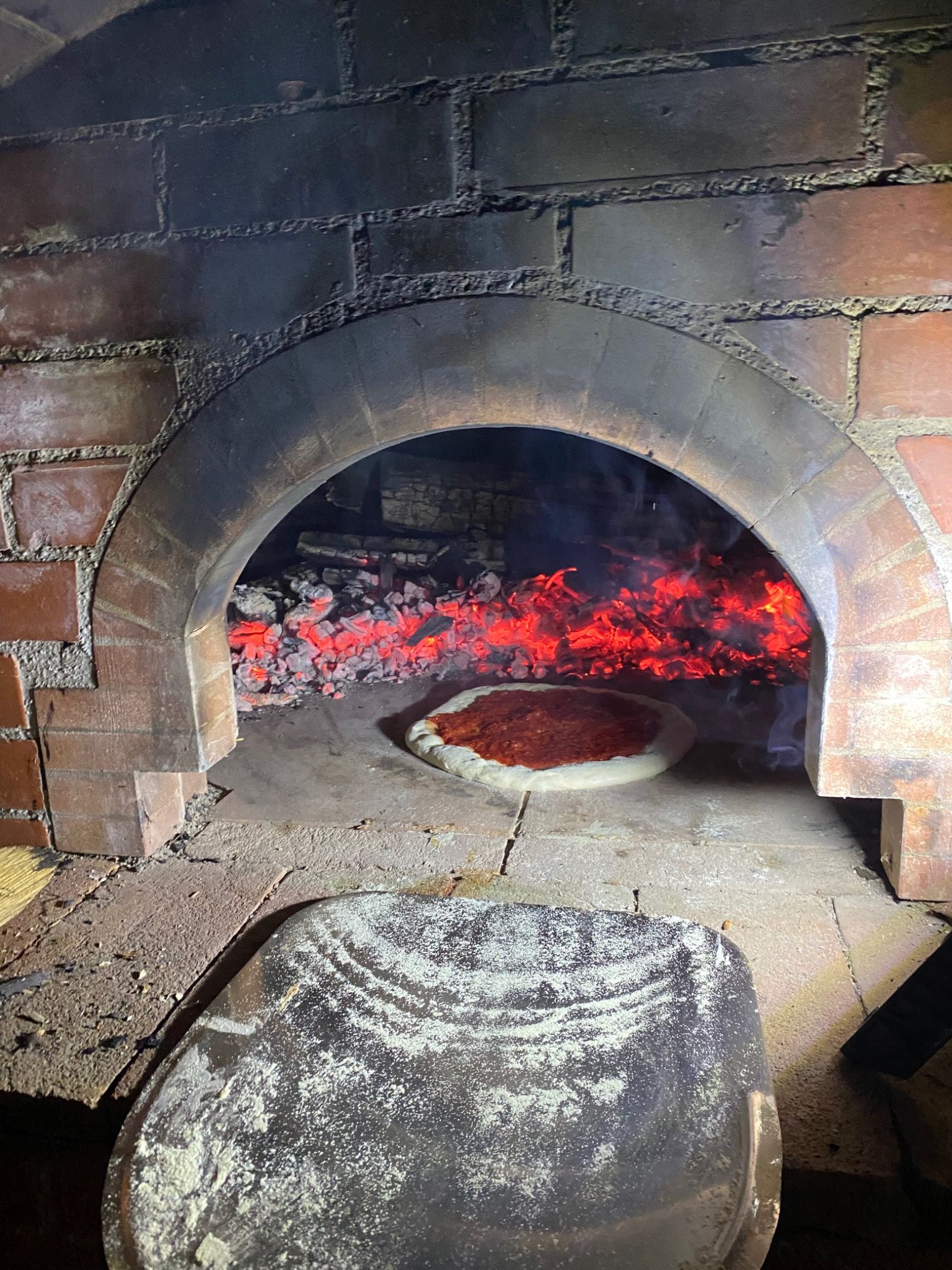 Pizza cooking in the original wood-fired oven